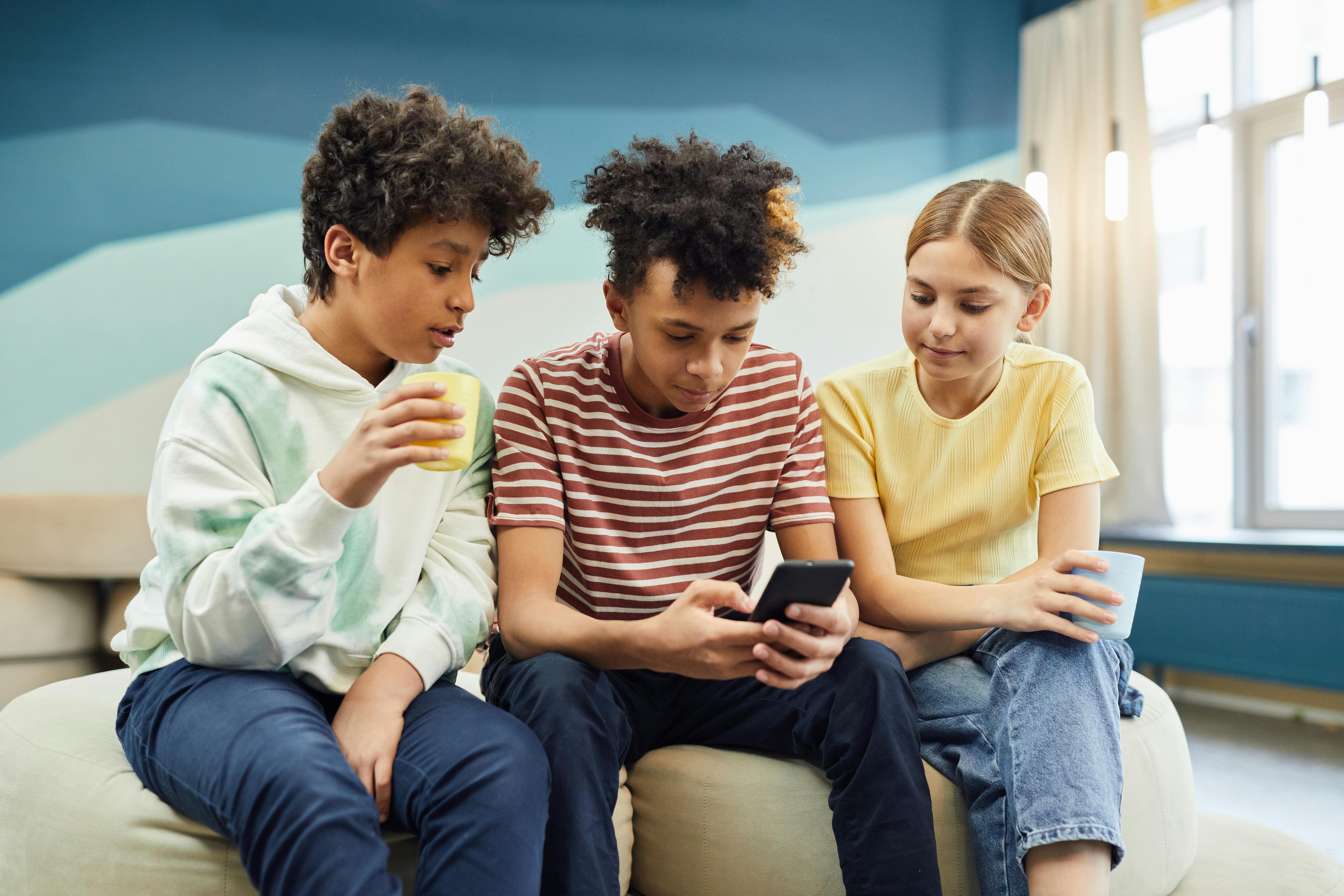 Children gathered around a phone | Source: Pexels