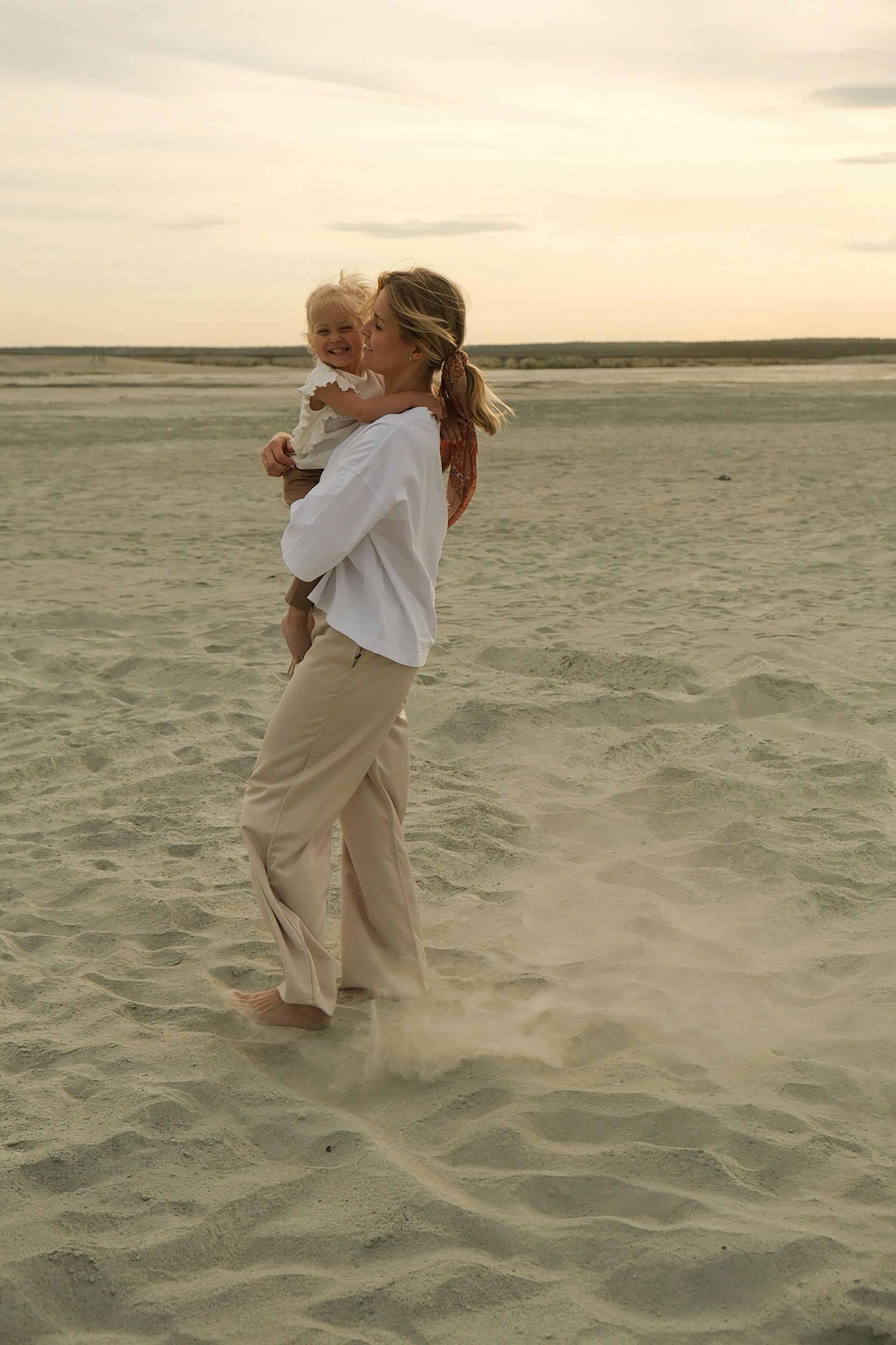 A woman holding a baby at the beach | Source: pexels