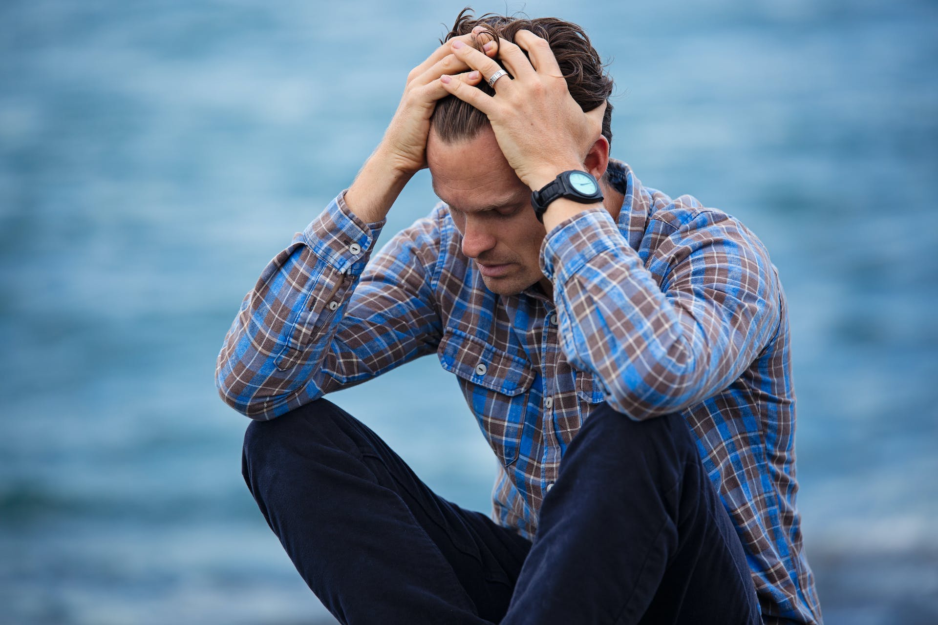 An upset man sitting by the river | Source: Pexels