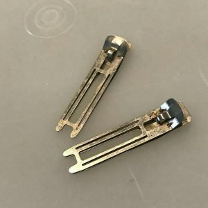 Found a whole box of these odd little metal clips while cleaning out my grandmother’s dresser. Any guesses? Found a whole box of these odd little metal clips while cleaning out my grandmother’s dresser. Any guesses?